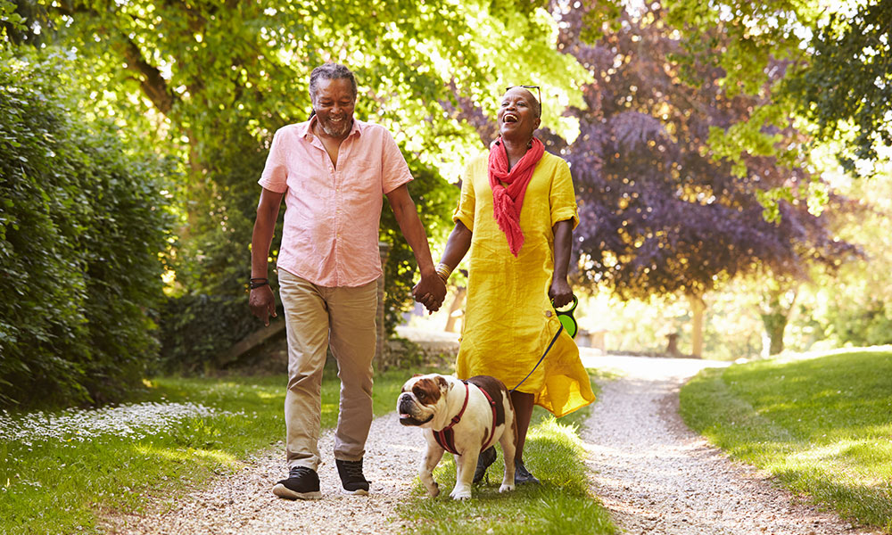 couple walking their dog outside greenspace