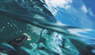 First person view of a person wearing a wetsuit and swimming