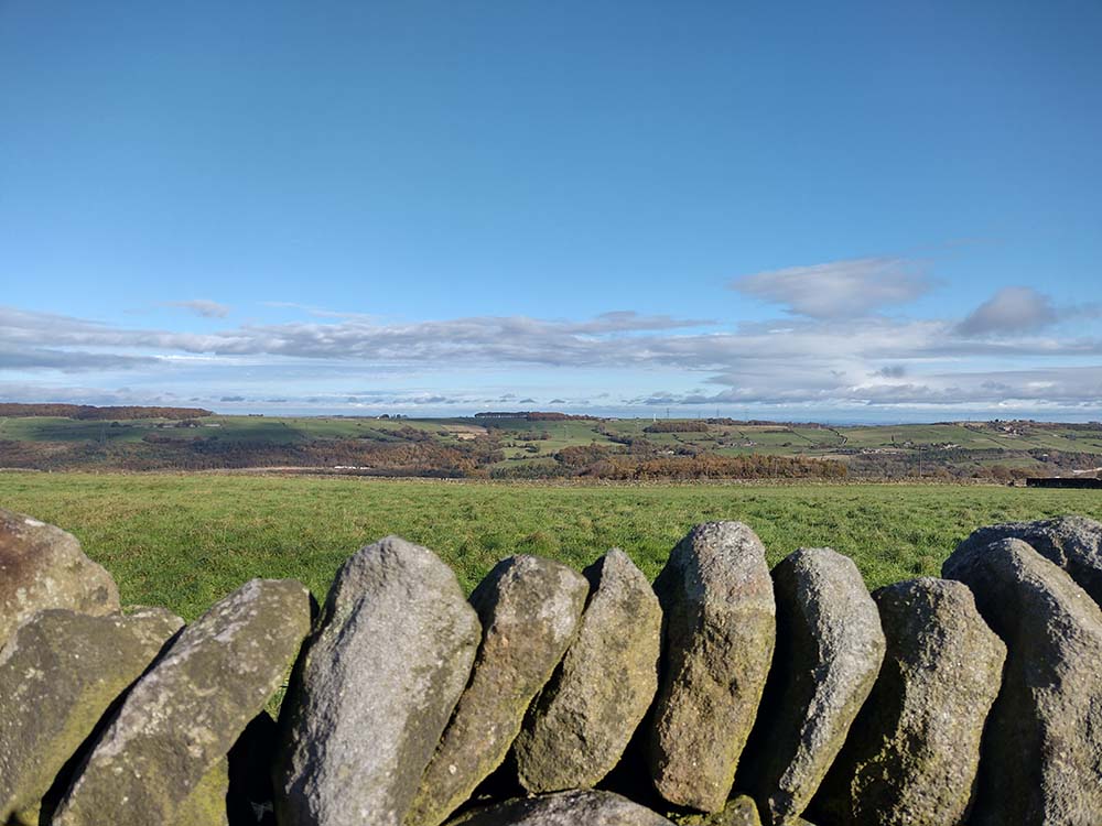 View over Stocksbridge valley with a dry stone wall in the foreground