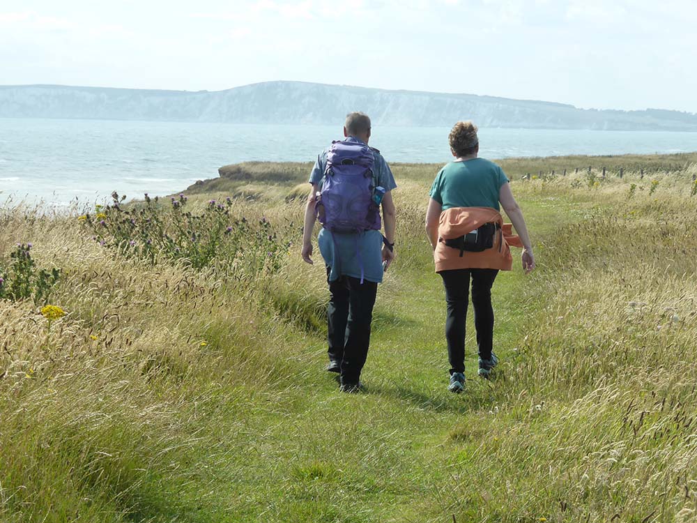 Isle of Wight Walks - walkers on the coastal path, tennyson down in the distance