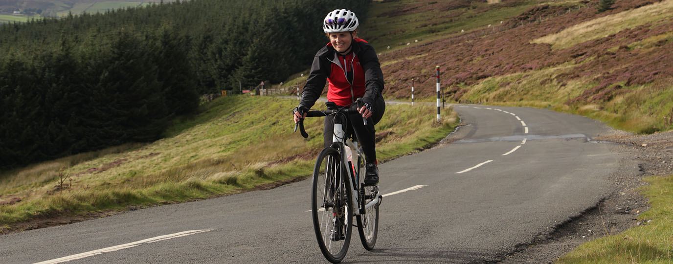 cycling coast to coast - Gee on her bike cycling uphill