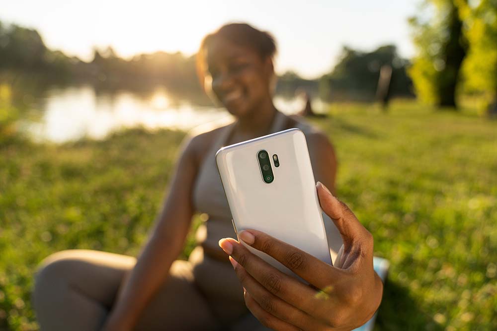 Plus size African American woman doing selfie after training in the park