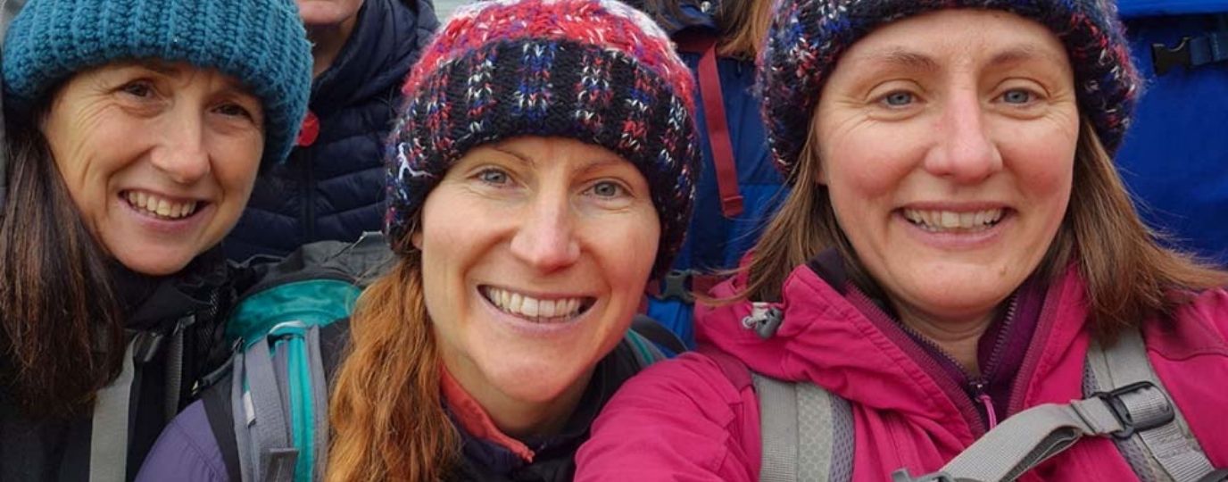 women smiling in bobble hats