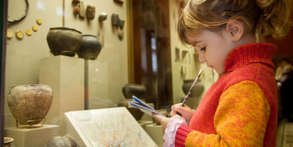 Girl engaging with artefacts in museum