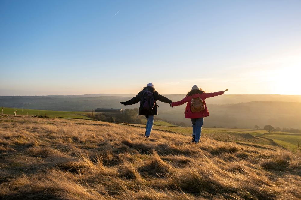 happy hikers running down a hill