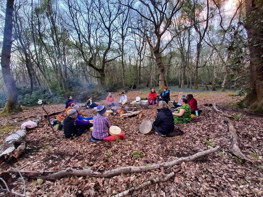 women sat in a circle in the woods