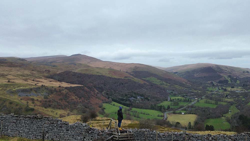 rolling hills of wales with a figure in the foreground
