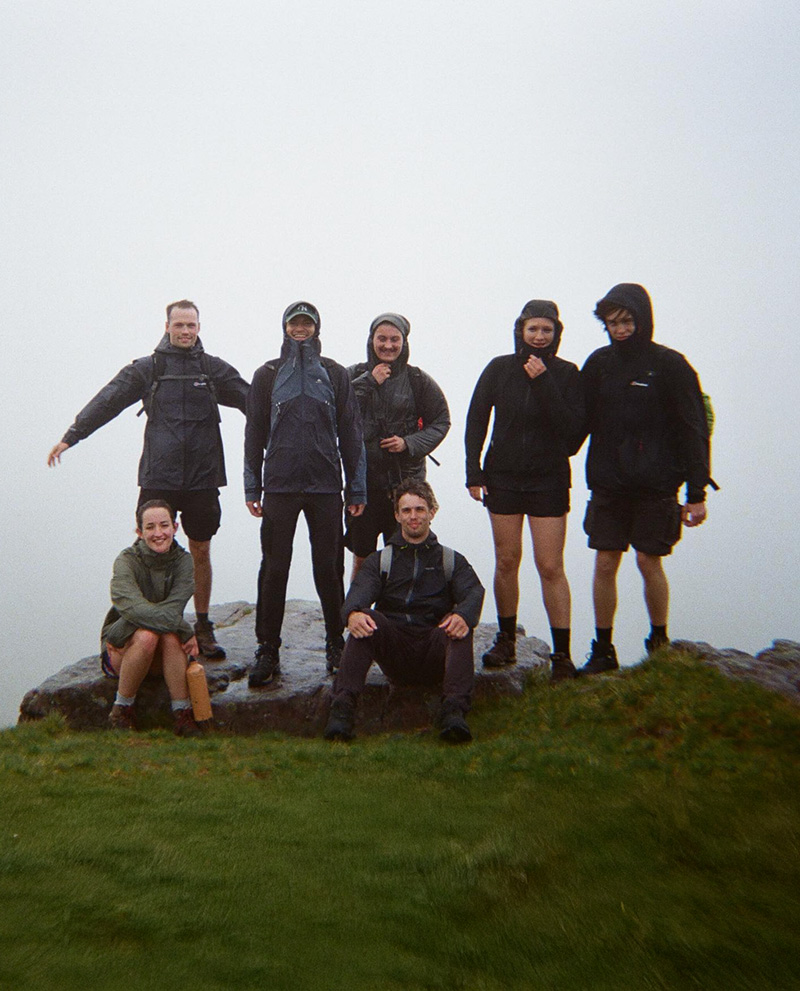Group of people posing on a wet rock outdoors