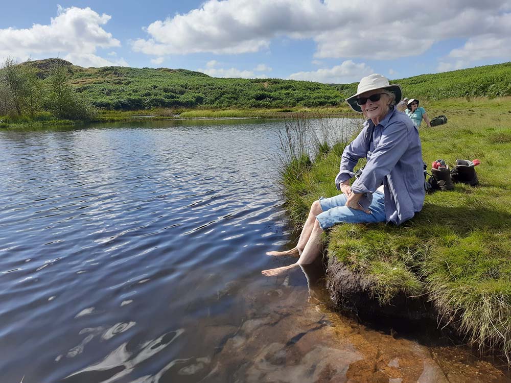 a women on a hike with her feet in a pool