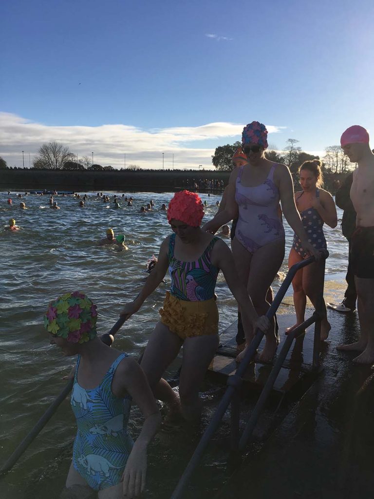 a group heading into the sea for a festive dip