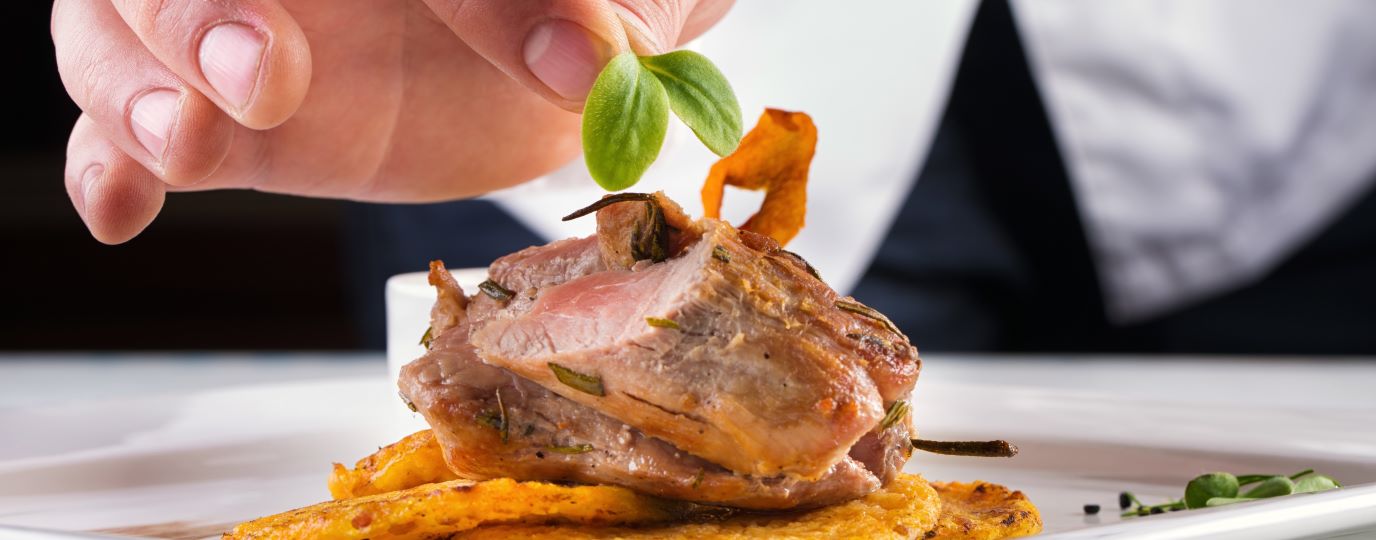 Chef adding garnish to a completed dish