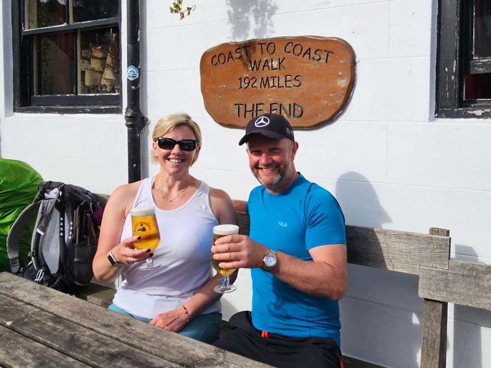 a couple enjoying a pint at the end of the coast to coast walk