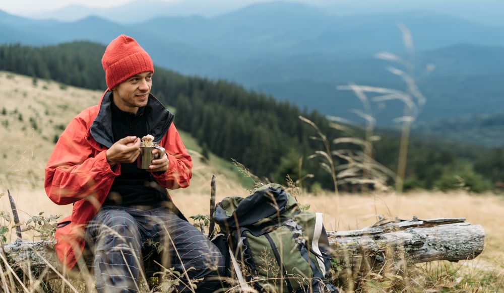 a man eating a snack on a hillside