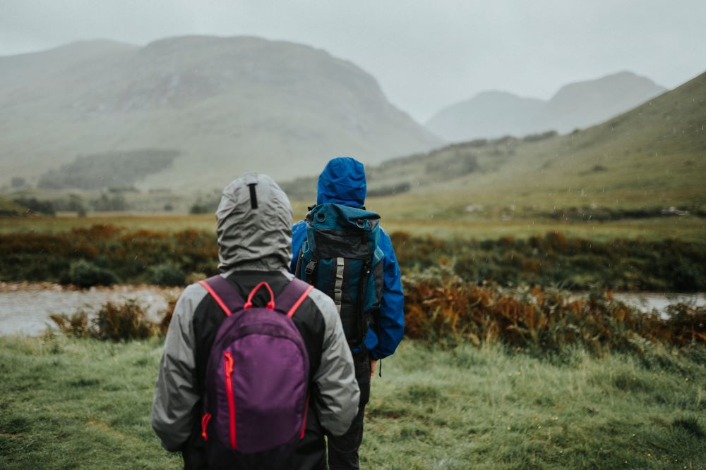 a couple hiking in the rain in the highlands