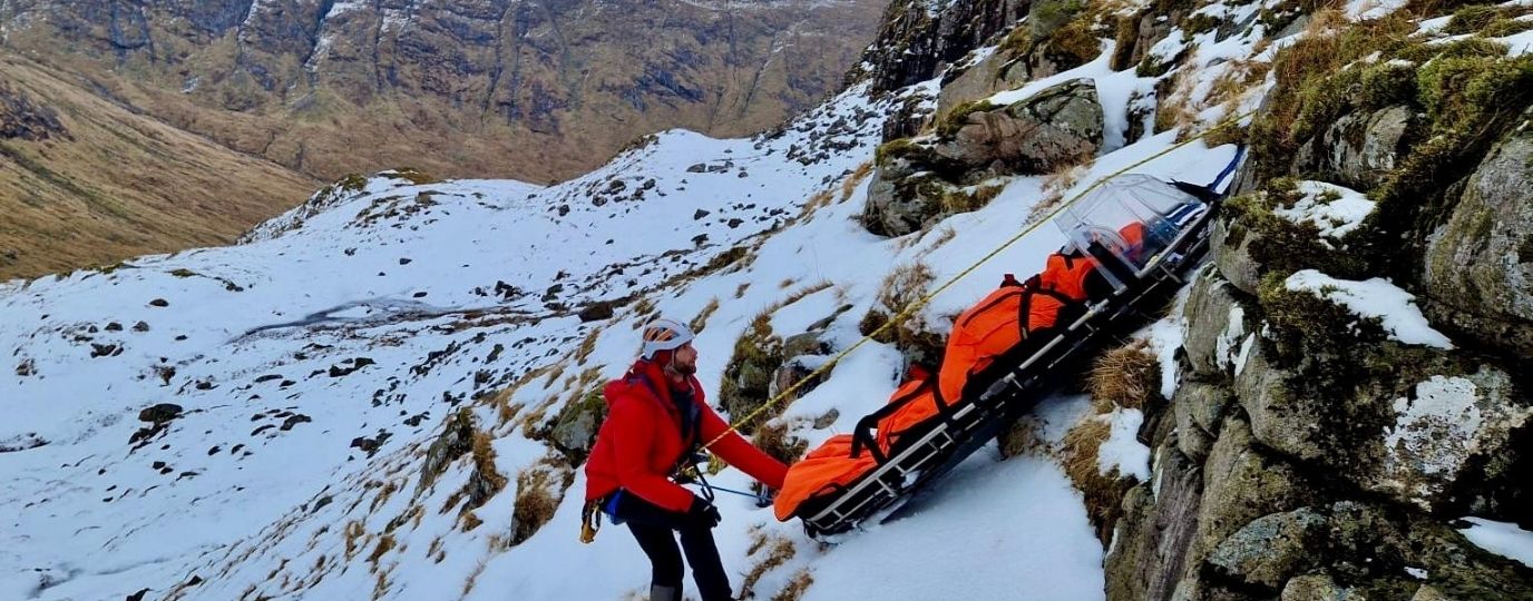 a man being stretchered off a mountain in the snow