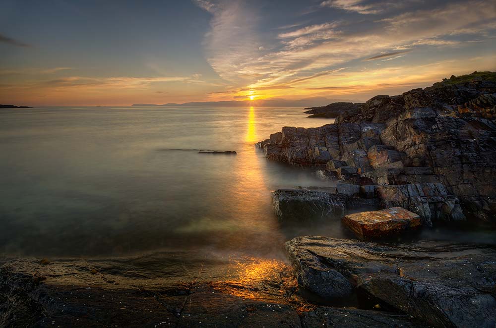 Rocky coast of Cuan Sound with sunset in background, Highland, Scotland