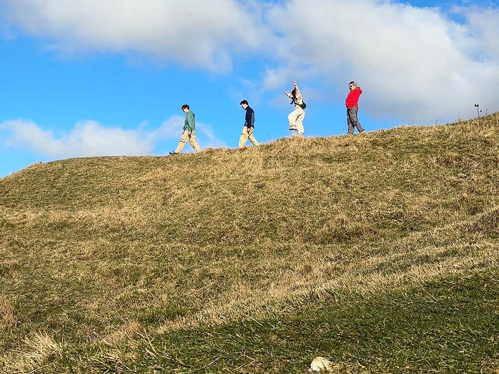 people on a ridge hiking in the sunshine