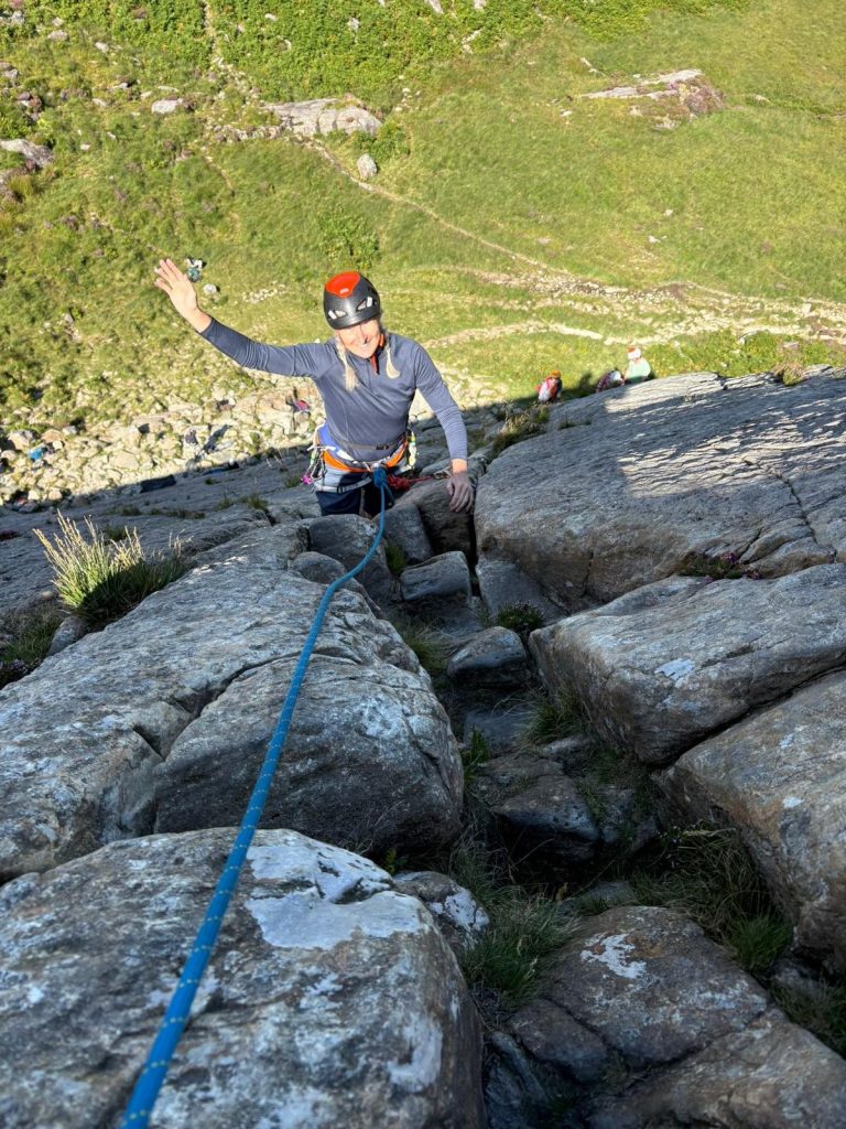 a female rock climber waving