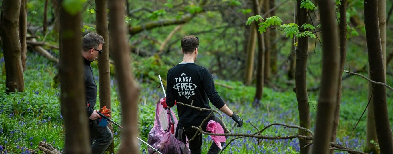a man collecting litter in bluebell woods