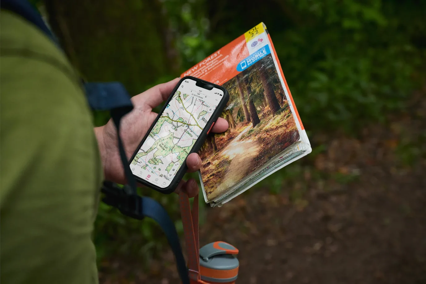 hand holding a phone and a map