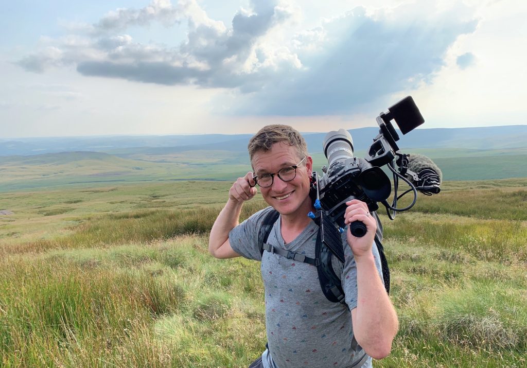 Will Millard with a big camera over his shoulder