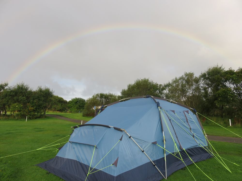 a rainbow behind a tent